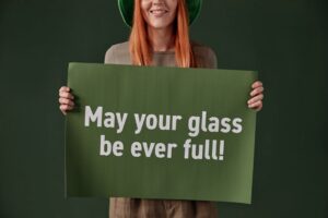 Woman holding St. Patrick's Day poster with cheerful message. Studio shoot.