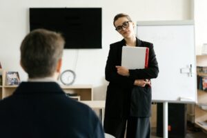 A businesswoman holding documents and presenting in a modern office.