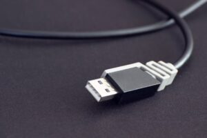 Detailed close-up of a black USB cable with a black background, highlighting connectivity technology.