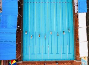 Overhead shot of swimmers racing in an outdoor pool in Indore, India.