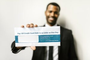 African American man holding envelope emphasizing credit card debt relief options.