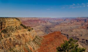 Breathtaking panoramic view of Grand Canyon's dramatic cliffs and valleys under clear skies.