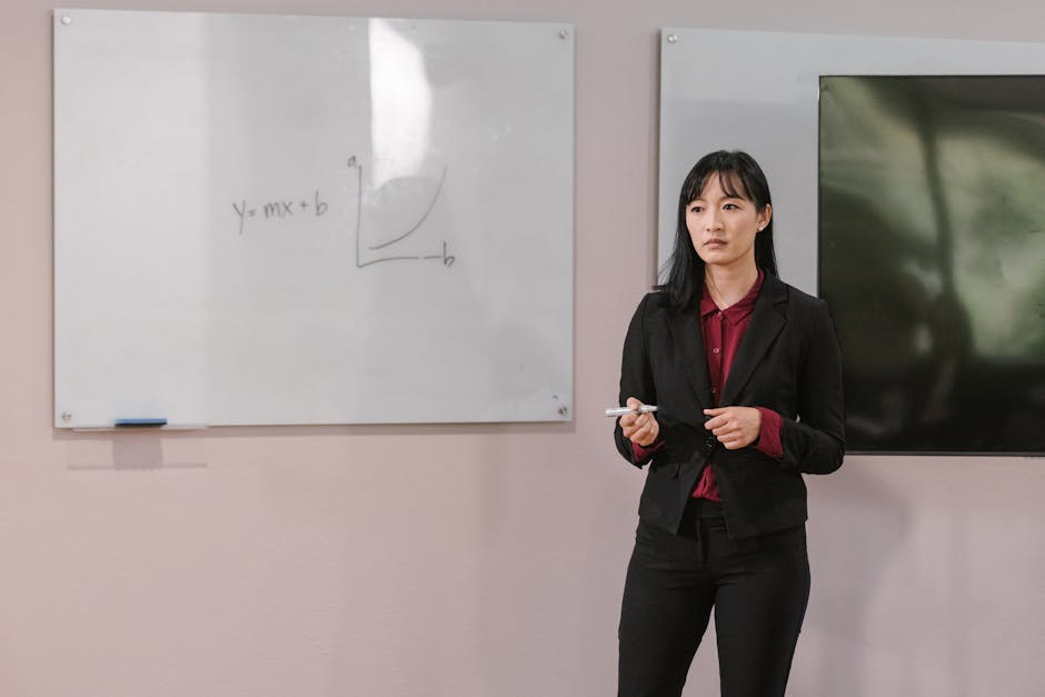 Businesswoman presenting on a whiteboard explaining financial concepts indoors.